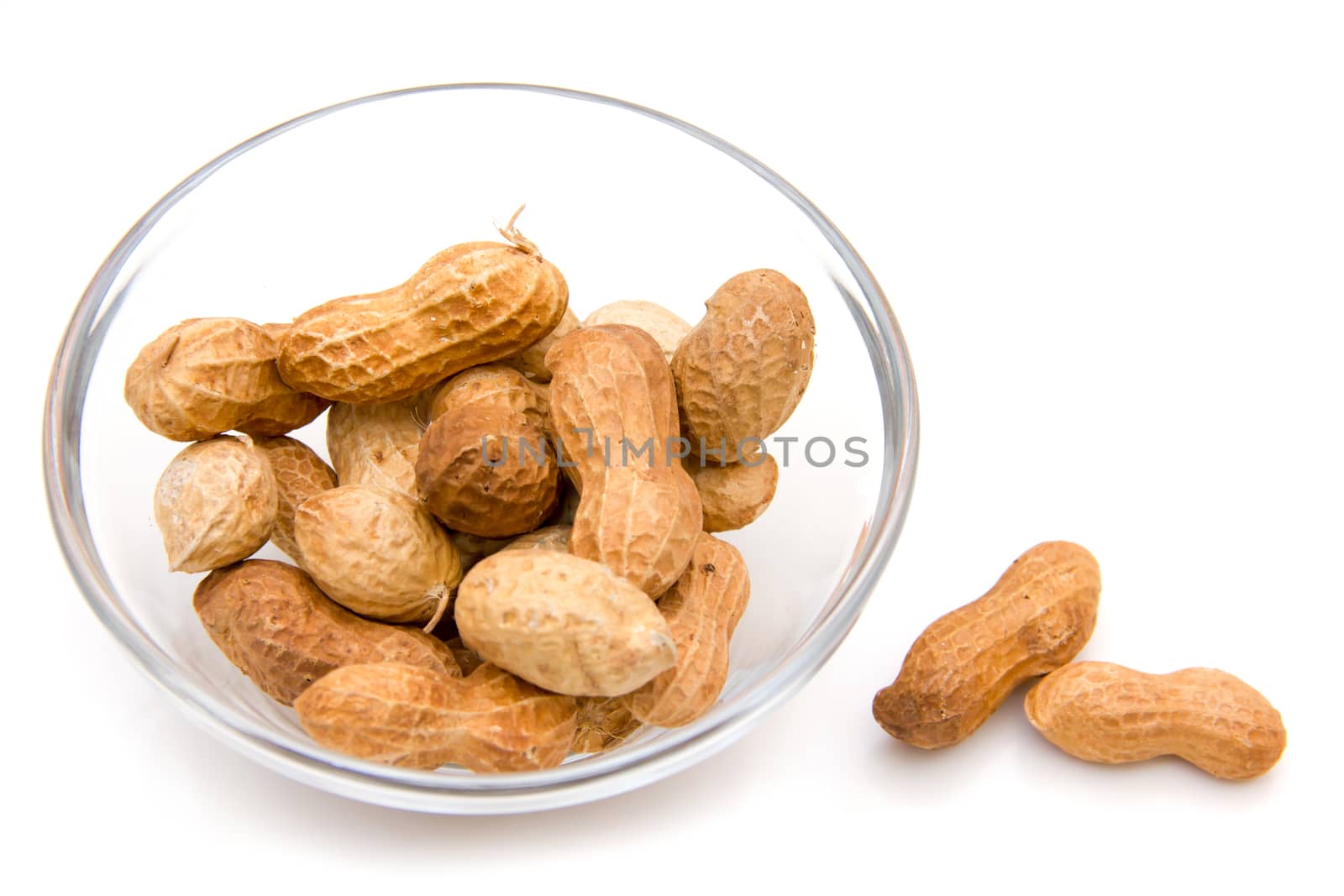 Peanuts on glass bowl on white background