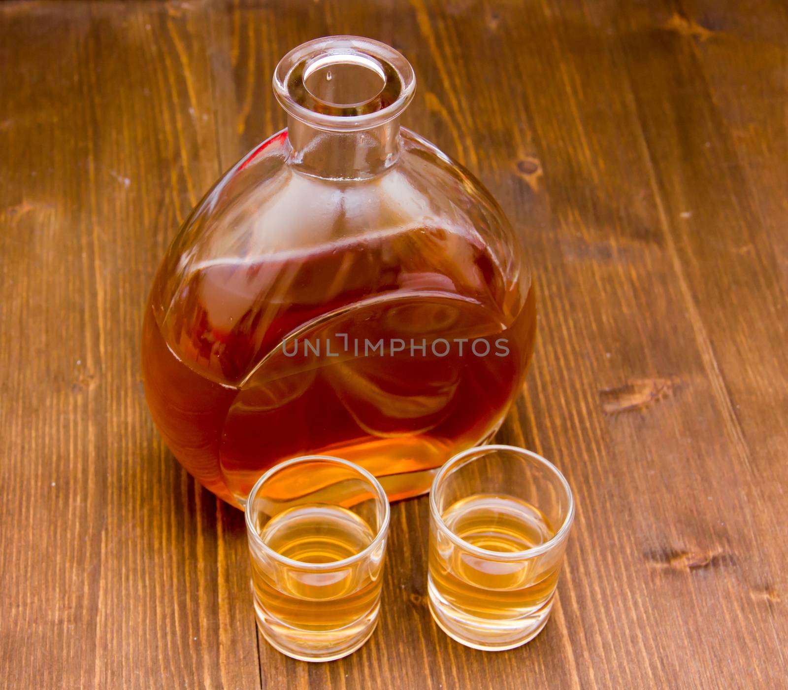 Whisky Bottle with glasses on wooden table