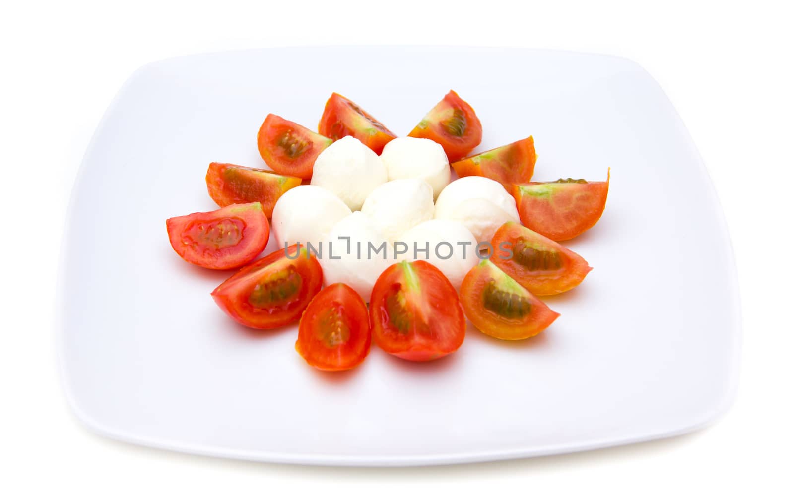 Plate with mozzarella and tomato on white background
