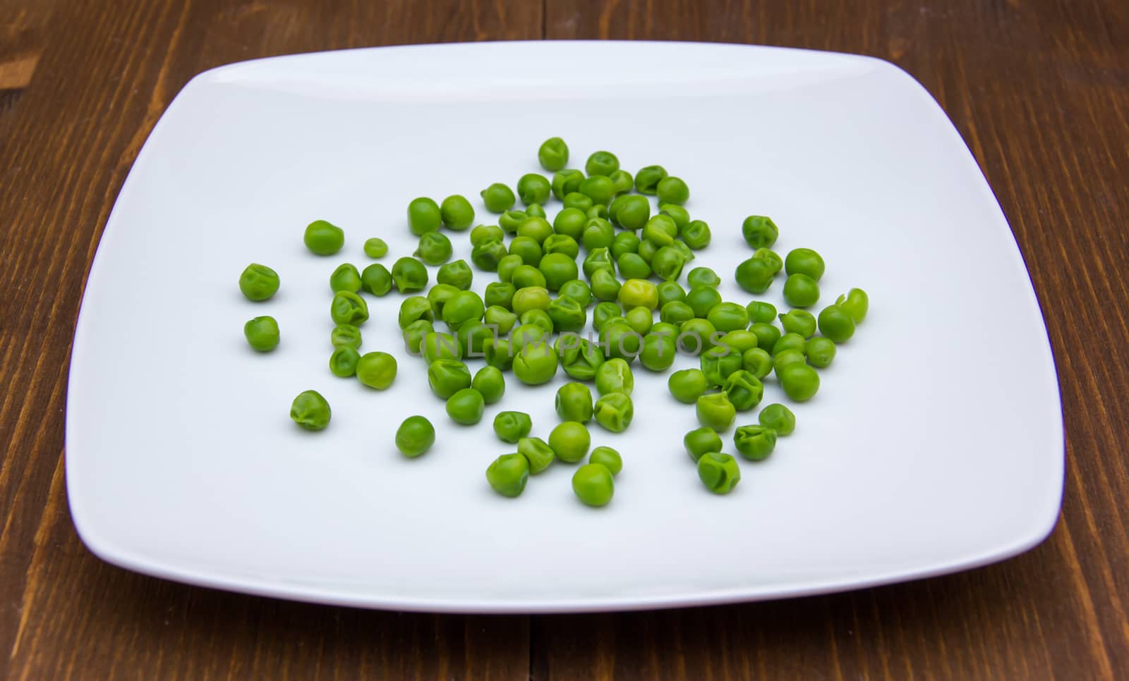 Plate with peas on wood by spafra