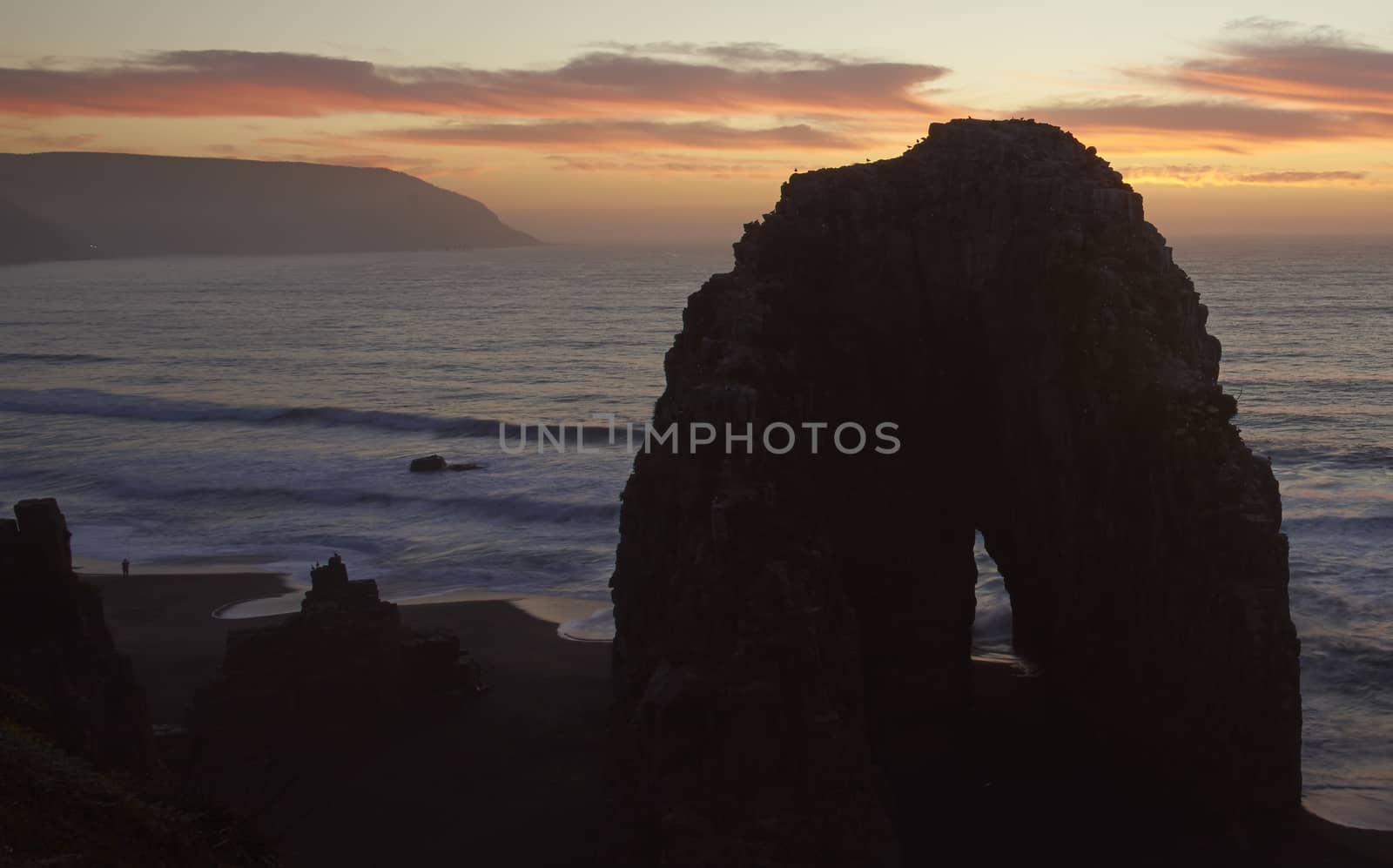 Colourful sunset over the pacific ocean at the coastal town of Constitucion in Maule, Chile. In the foreground are the Rocas de los Calabocillos, which are home to thousands of seabirds.