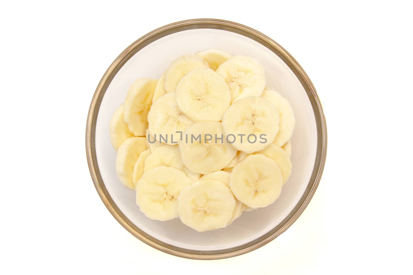 Banana slices on bowl on white background viewed from above