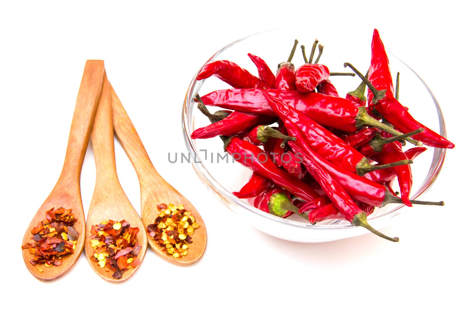 Peppers on the bowl and spoons on a white background