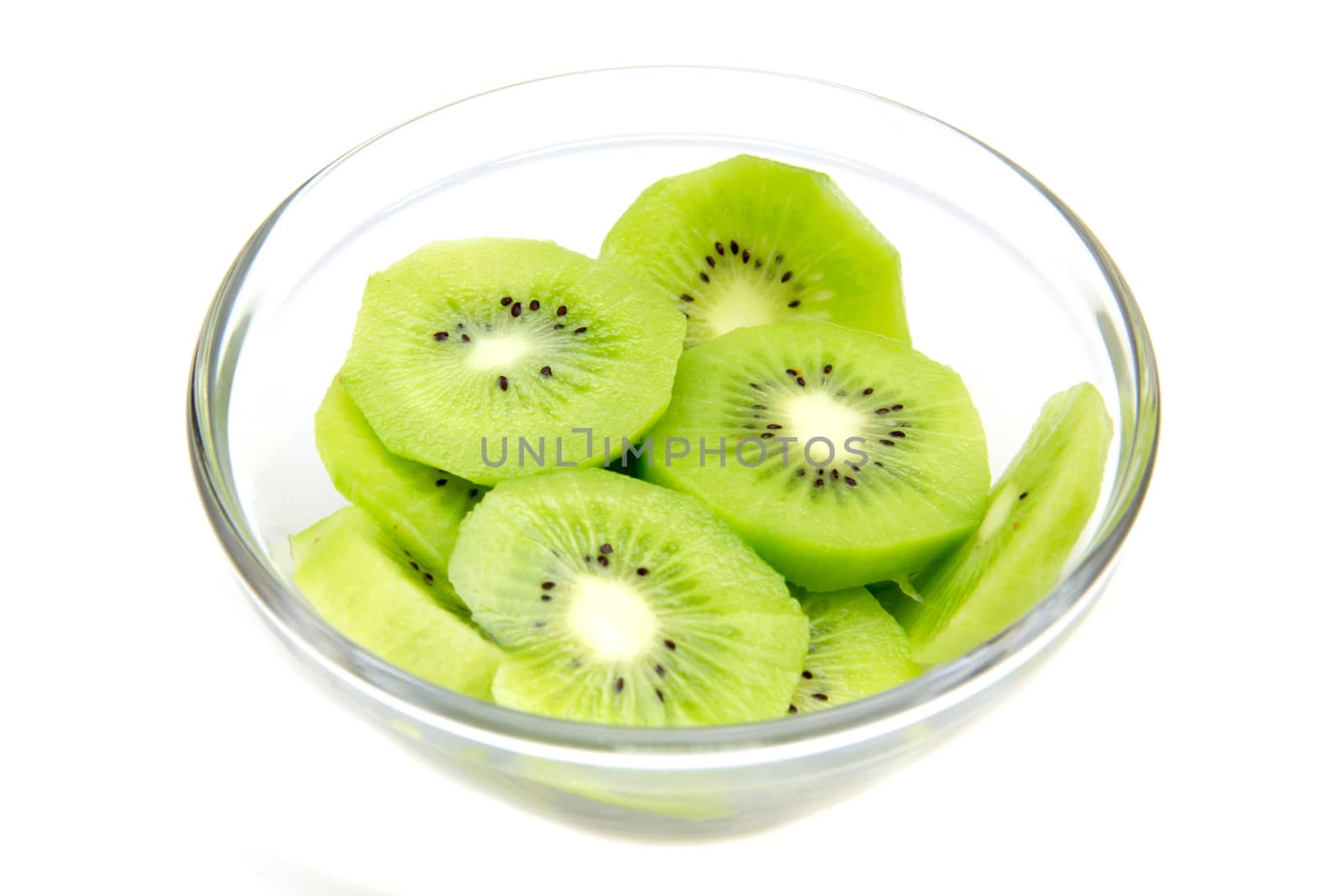 Slices of kiwi fruit on bowl on white background