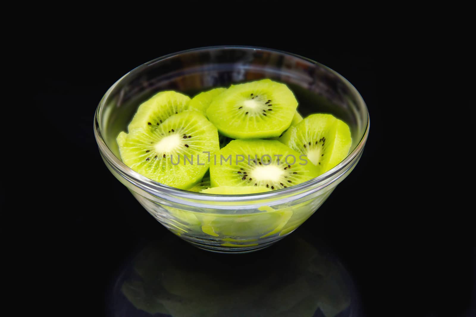 Slices of kiwi on black bowl on by spafra