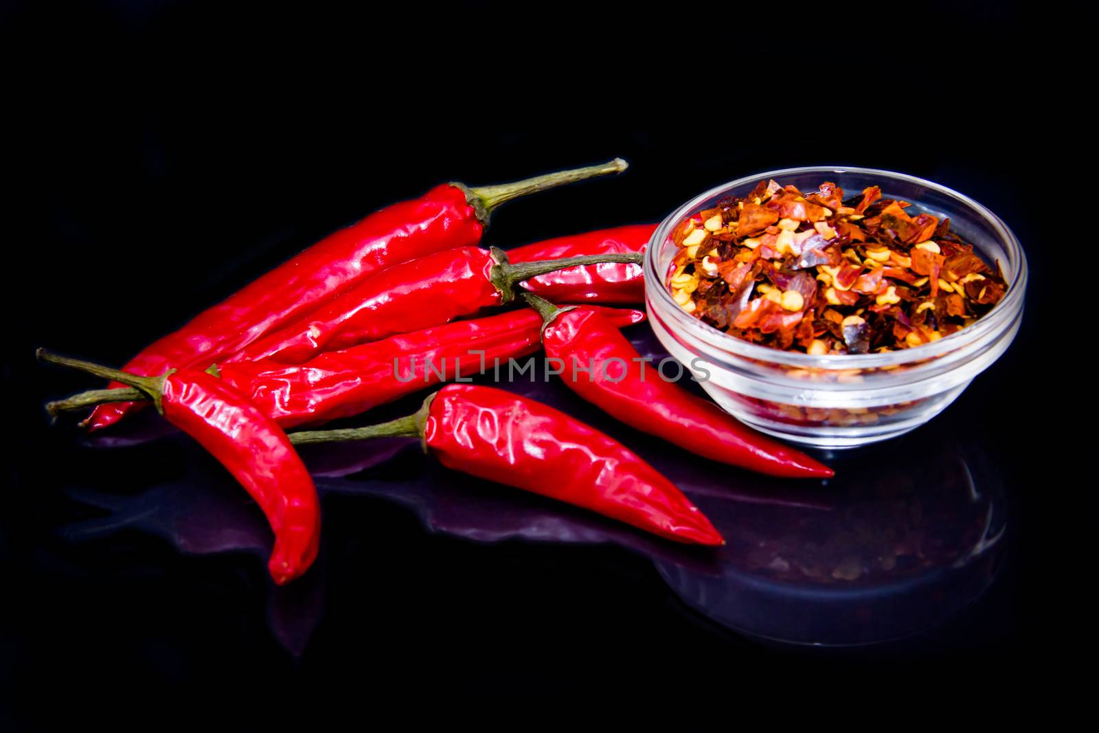 Chillies which are reflected on a black background