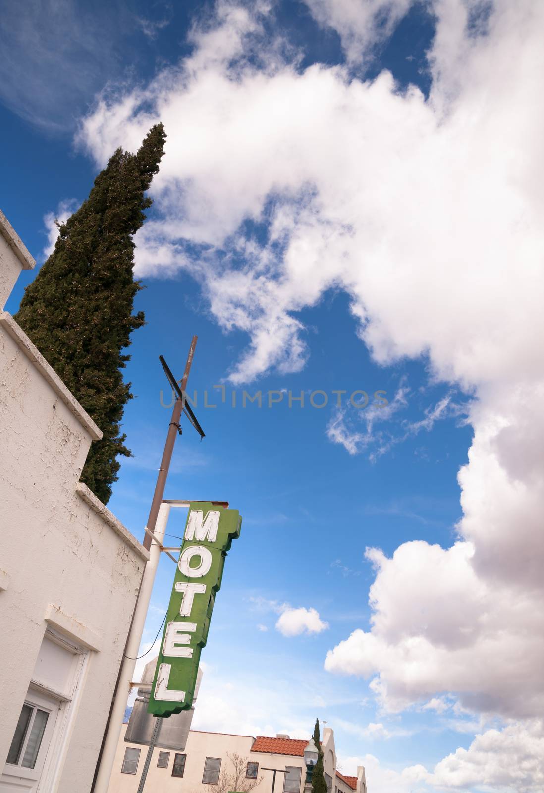 Neon Motel Sign Clear Blue Sky White Billowing Clouds by ChrisBoswell