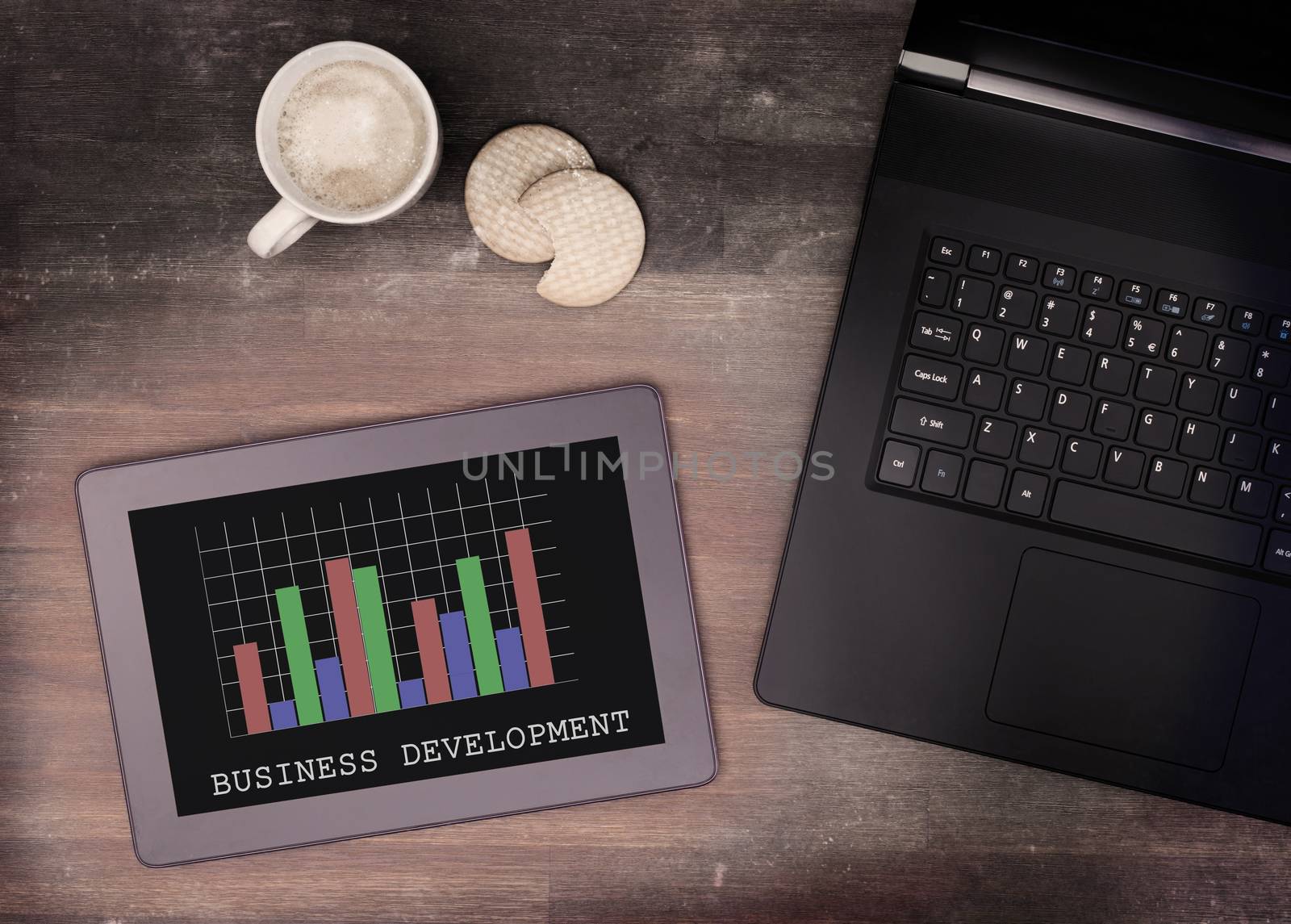 Tablet touch computer gadget on wooden table, graph, vintage look