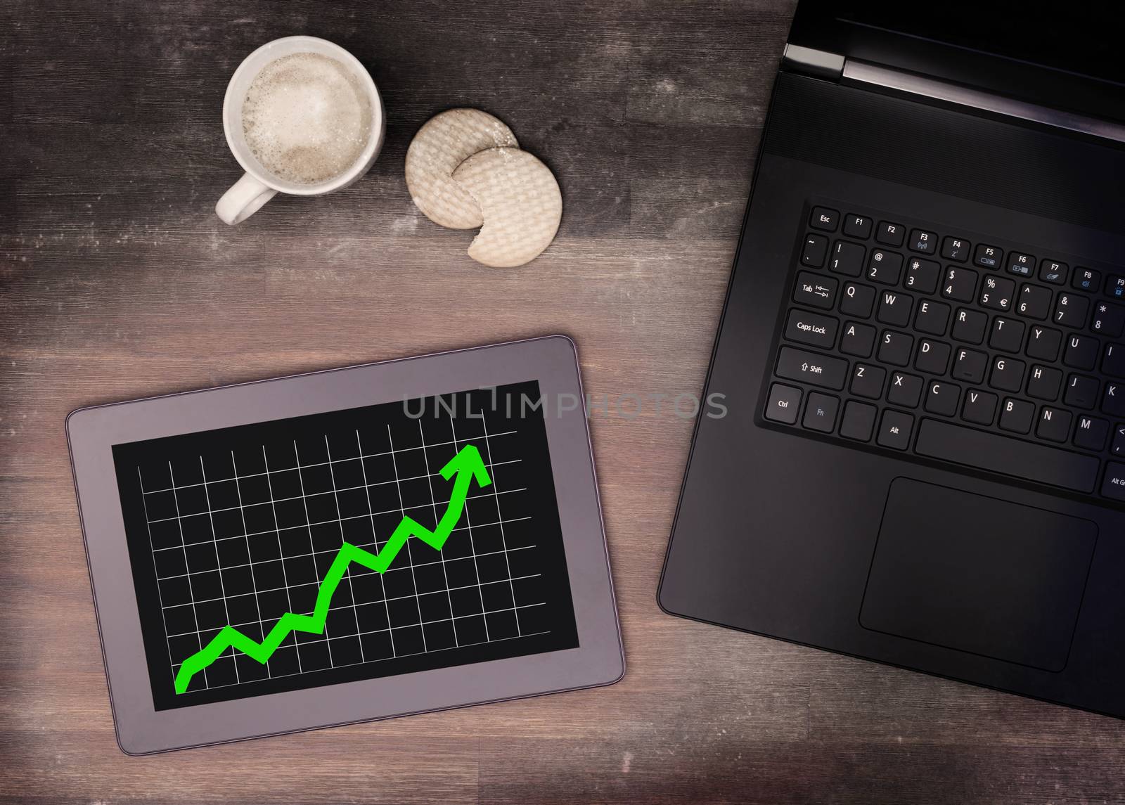 Tablet touch computer gadget on wooden table, graph positive, vintage look