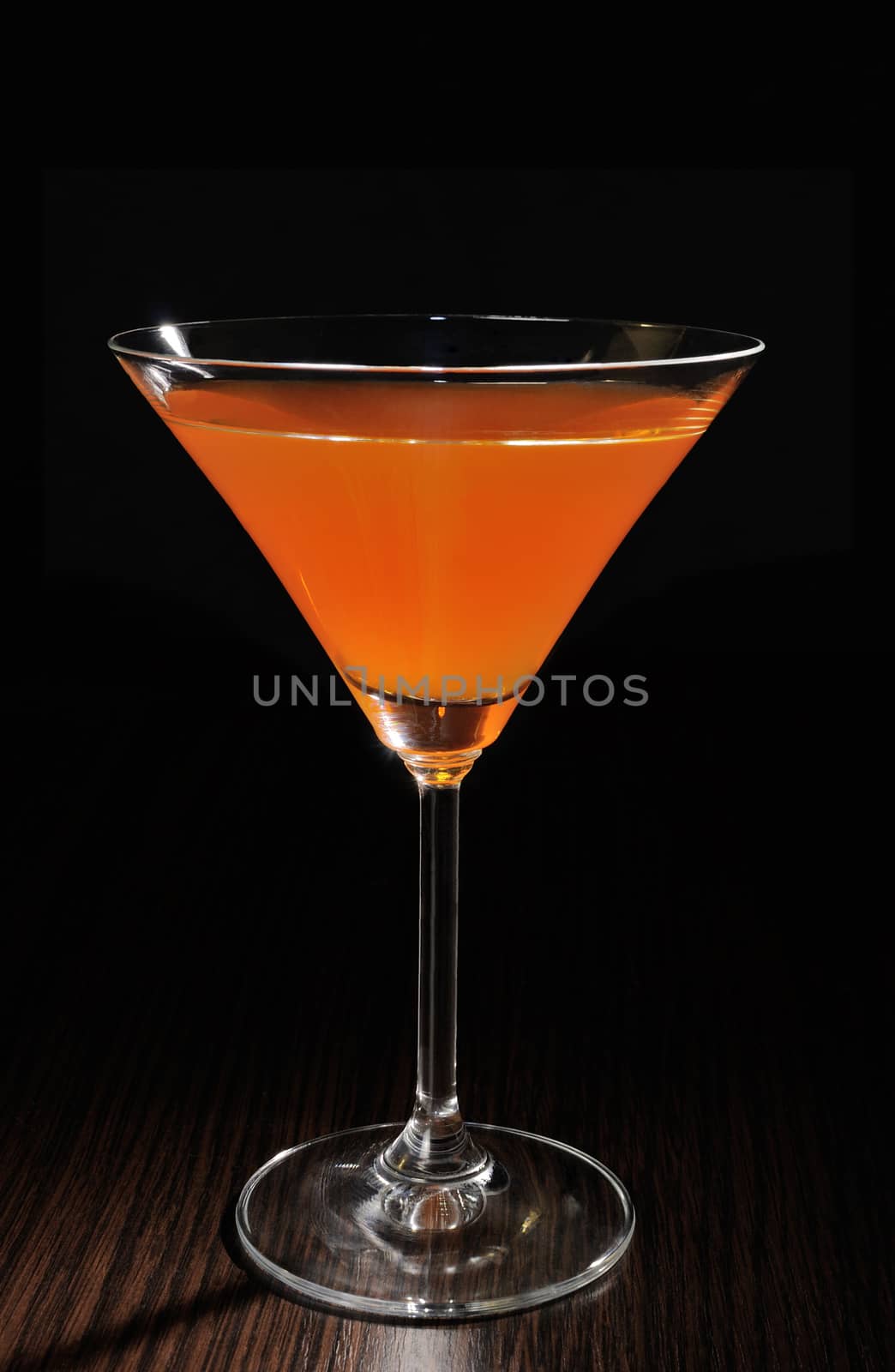 Orange cocktail in a glass on the table