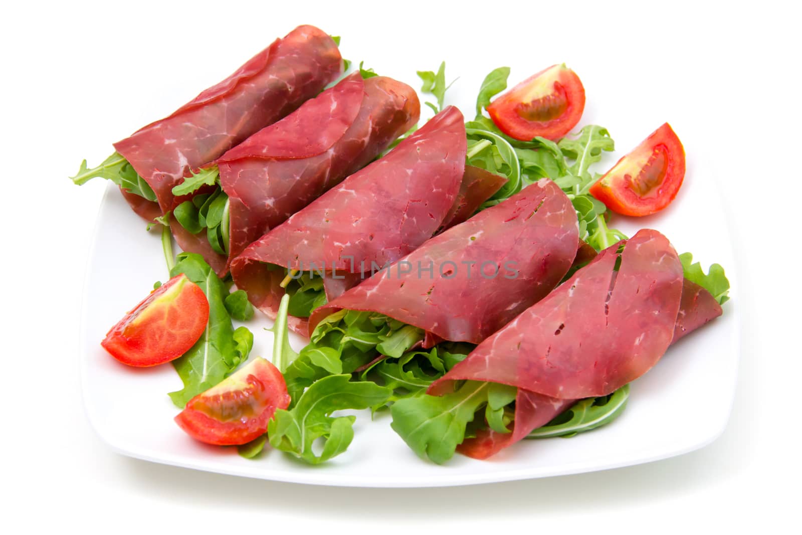 Rolls of dried beef on plate on white background