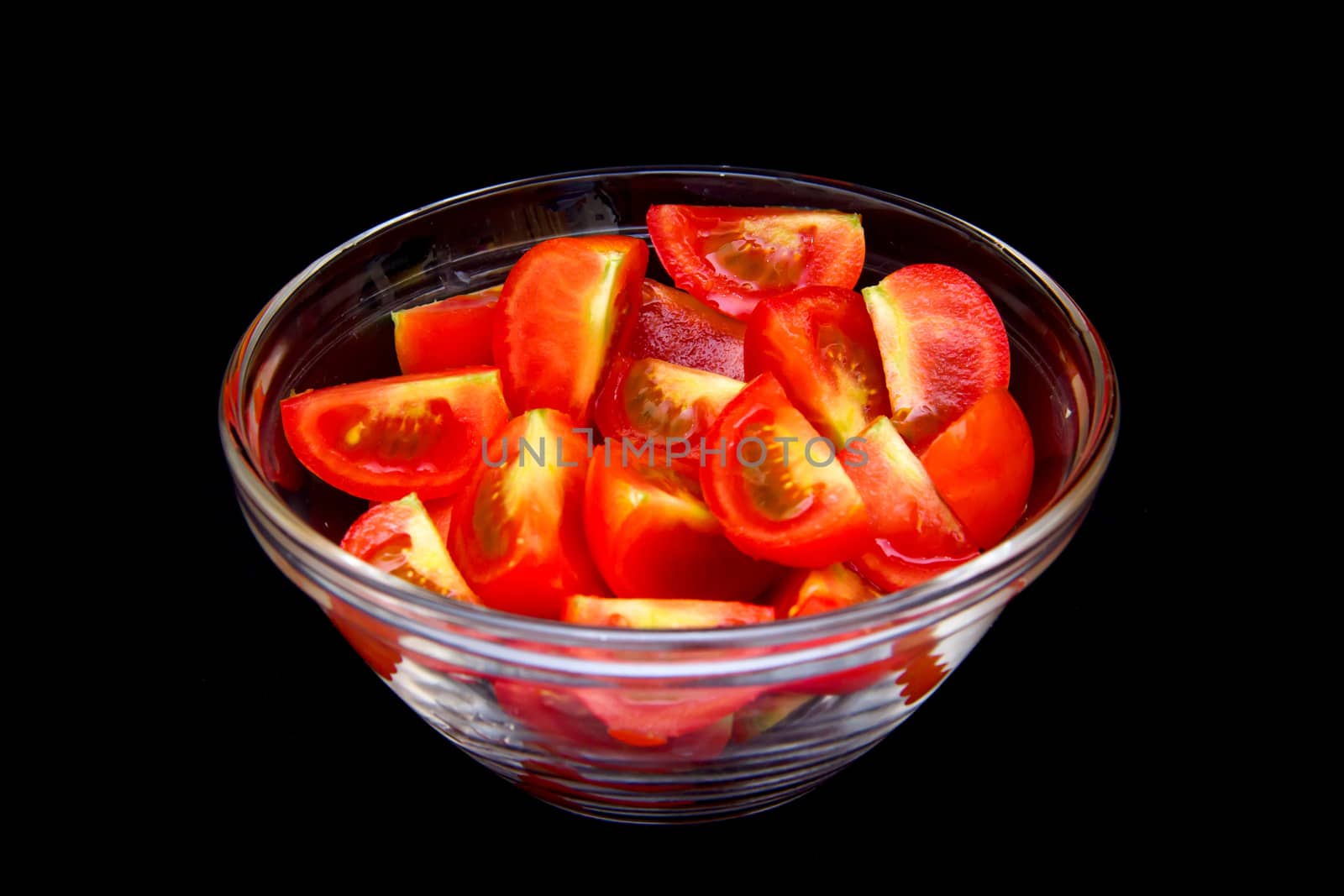 Bowl of tomato wedges on a black background