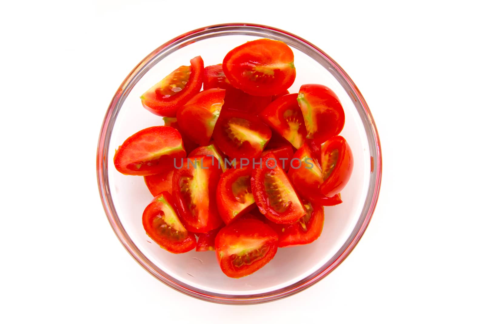 Slices of tomato on bowl on white background seen from above