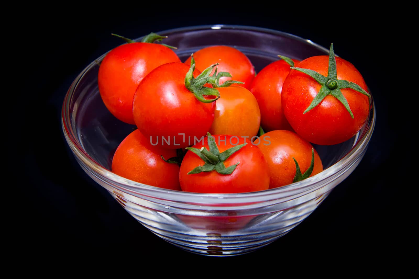 Tomato on bowl on a black background
