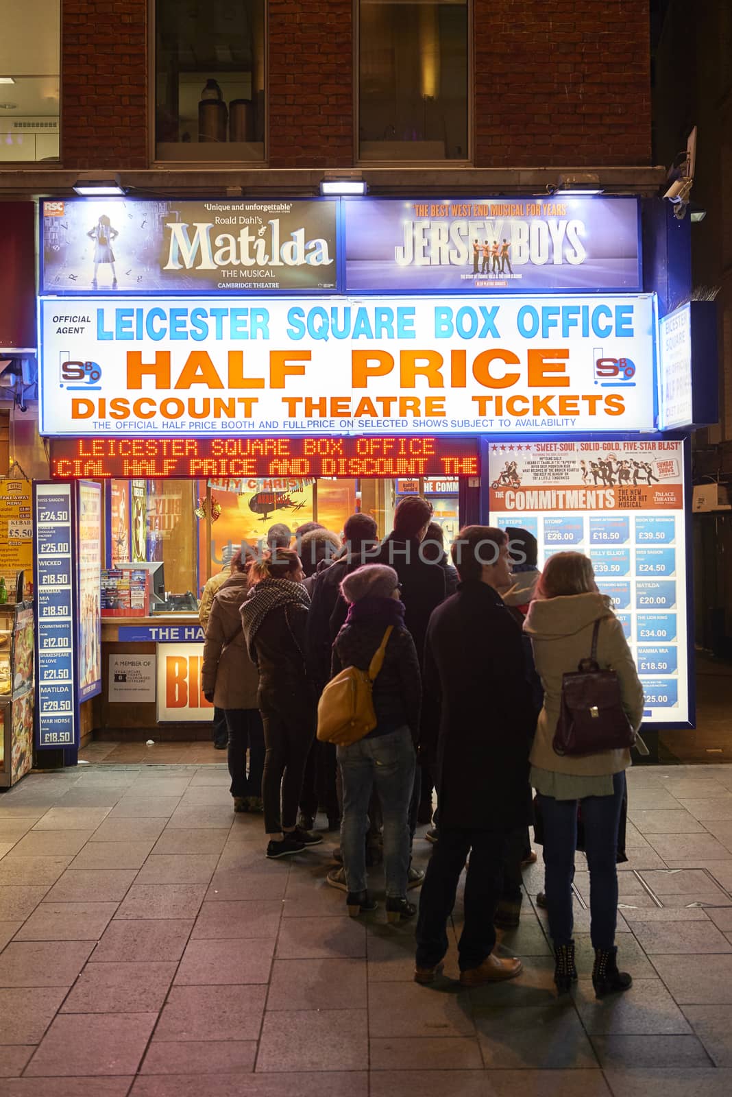 LONDON, UK - JANUARY 02: People lined up for discounted theatre tickets at night in Leicester Square. January 02, 2015 in London.