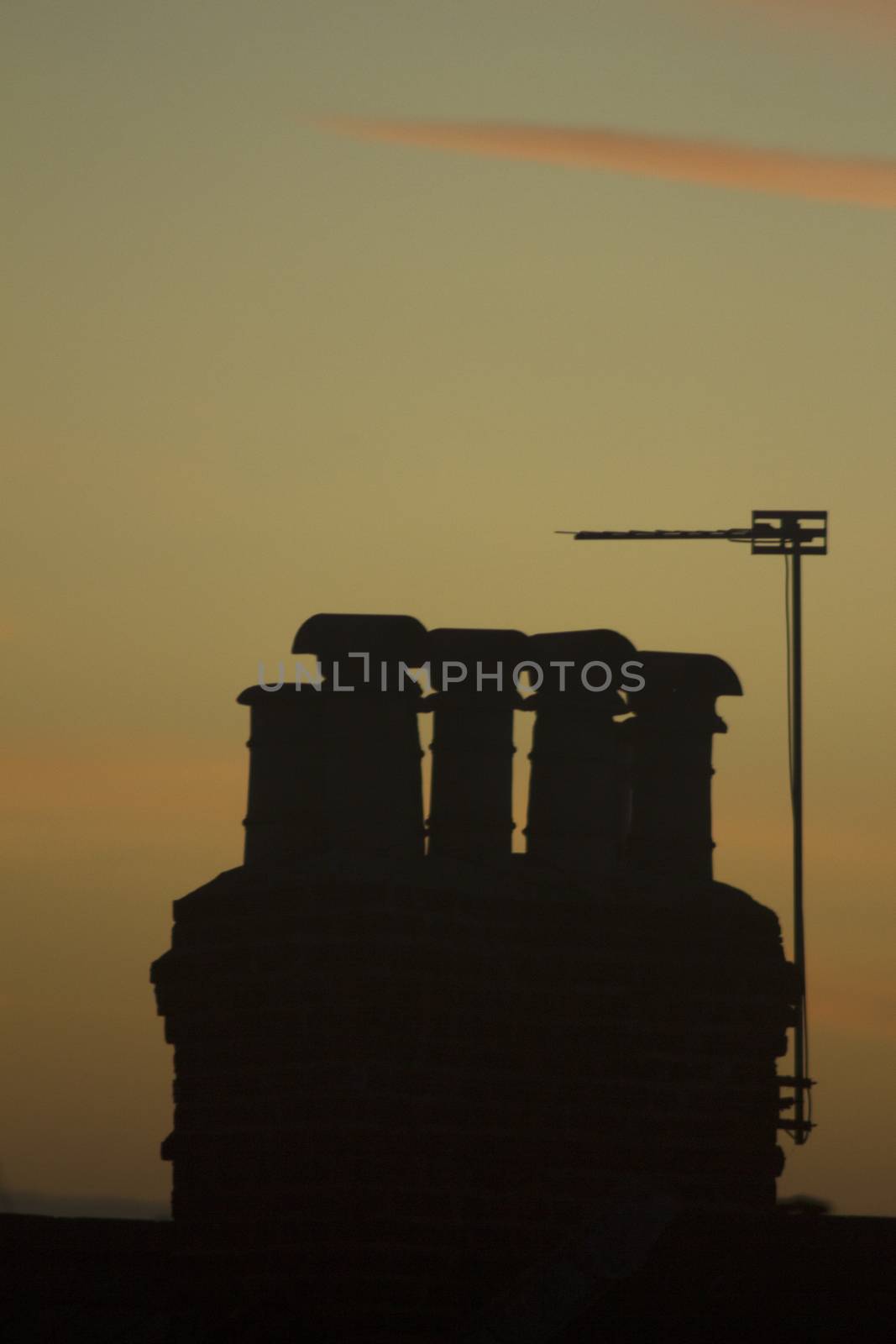 TV arial television antenna and chimney on roof of an urban high rise building and attractive blue purple dusk sunset sky in London England. 