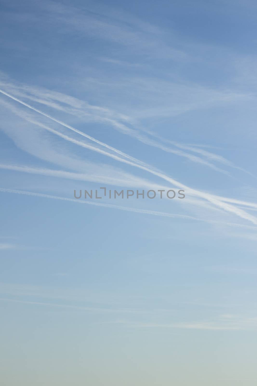 Blue sky with clouds airplane vapor trails by edwardolive
