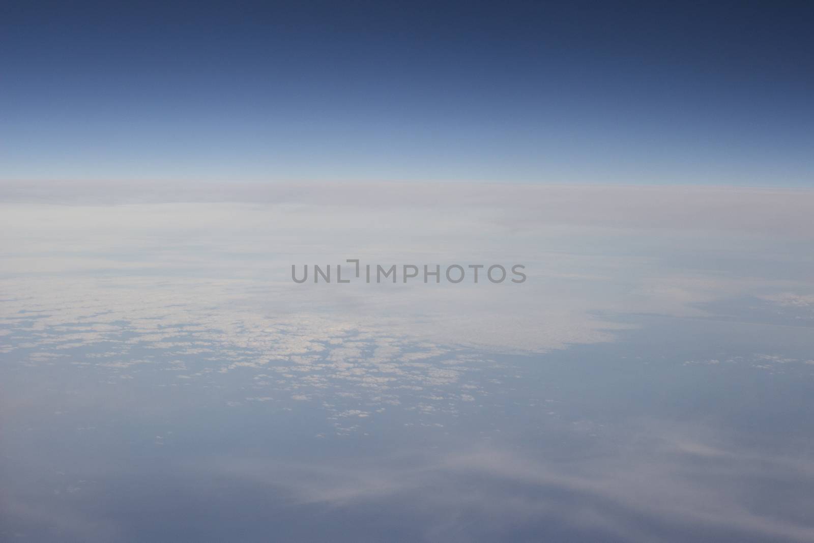 Blue sky with clouds seen from plane window by edwardolive