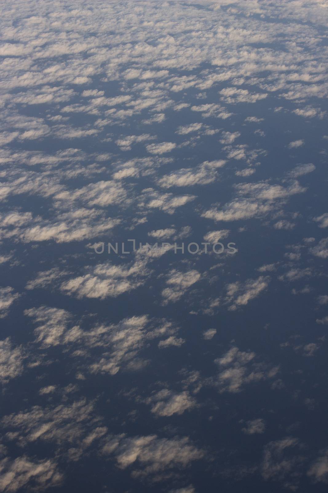 Blue sky with clouds seen from plane window by edwardolive