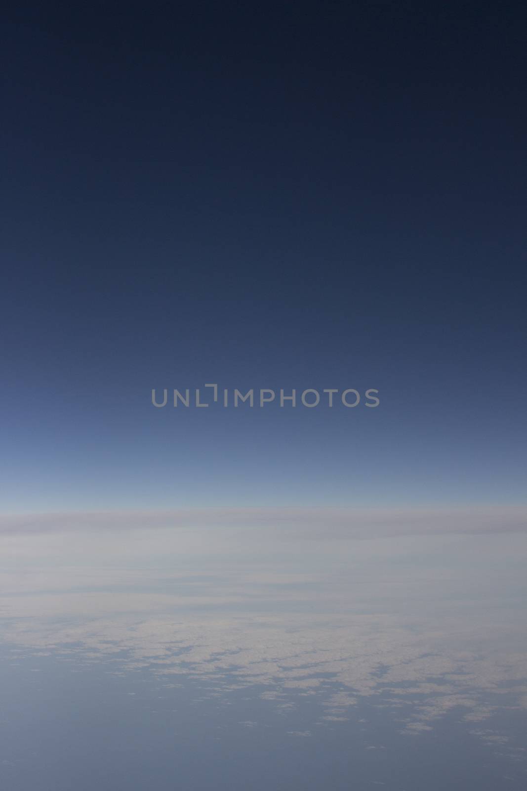 Blue sky with clouds seen from plane window by edwardolive