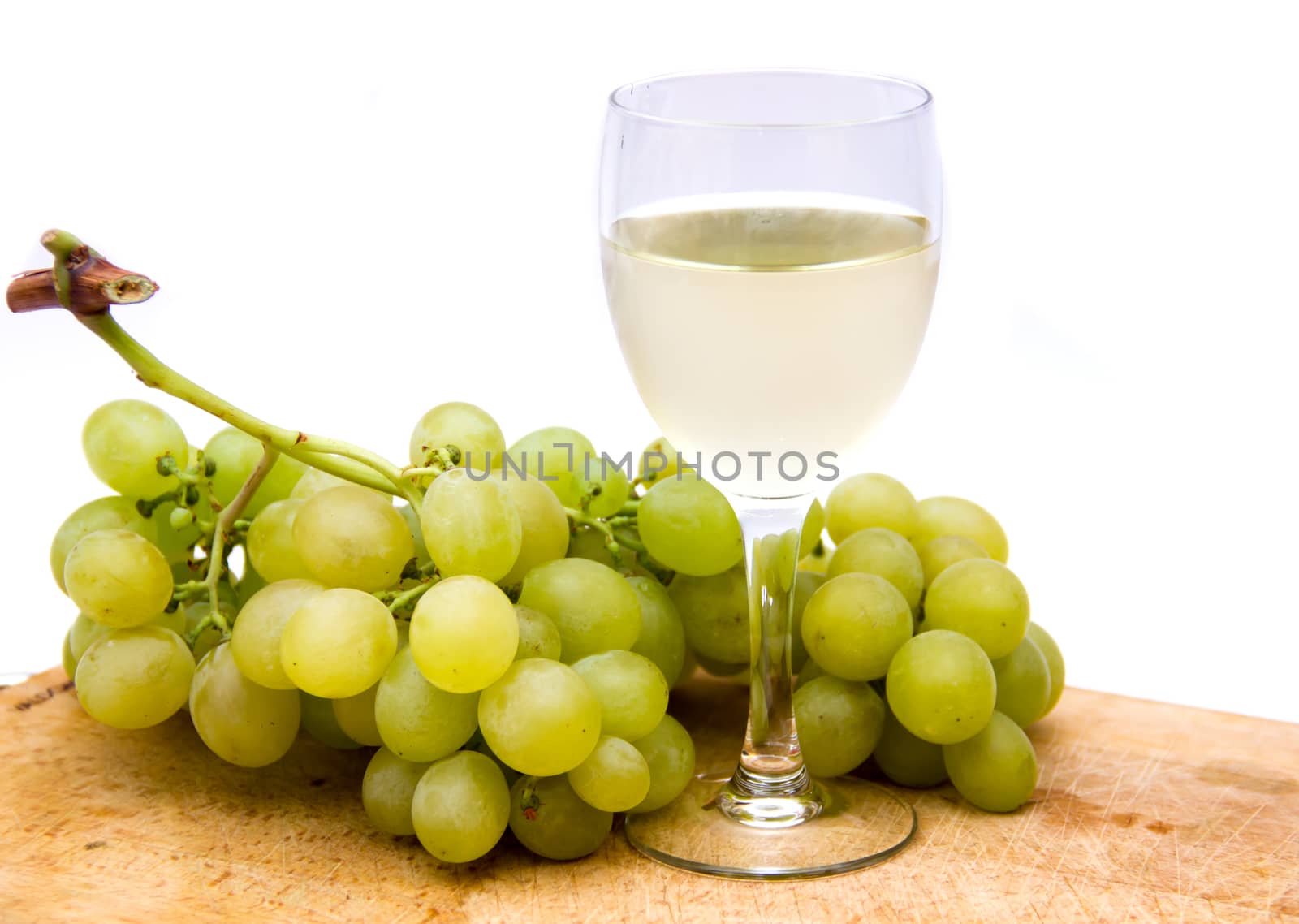 White wine with grapes on a cutting board on white background