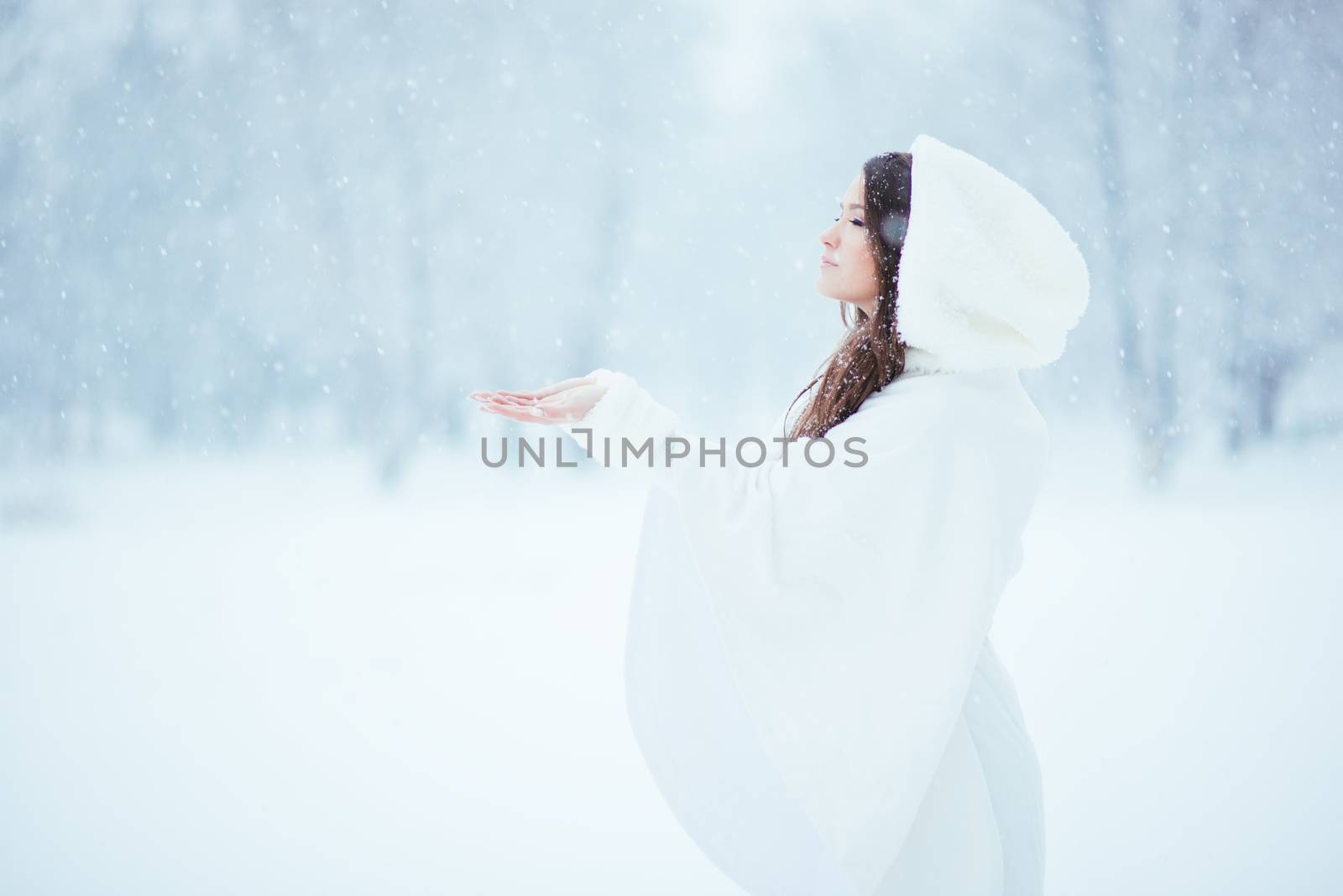 Girl alone in the snow, enjoying the tranquility and quietness of the snowfall
