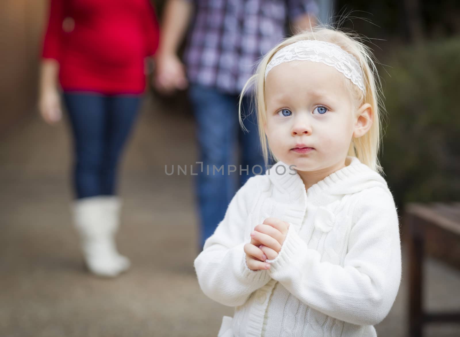 Adorable Little Girl with Her Mommy and Daddy Portrait Outside.