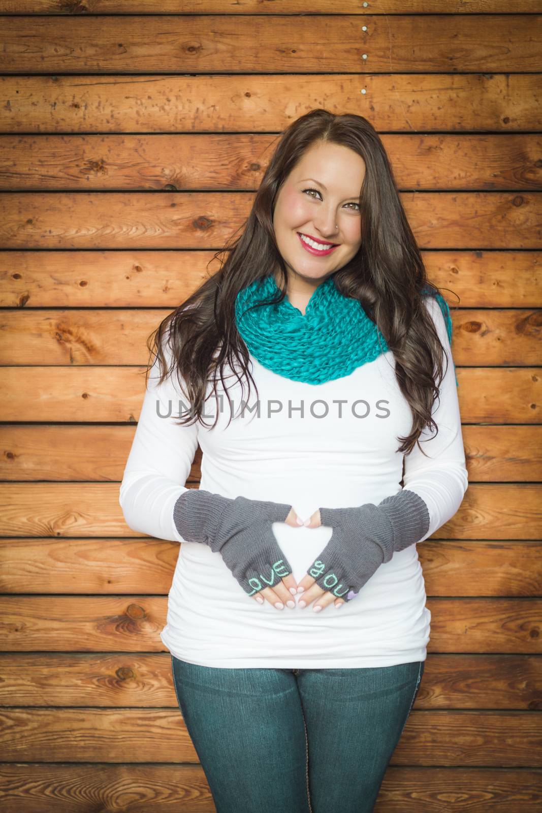 Beautiful Young Pregnant Woman Holds Her Stomach with Love You Mittens.