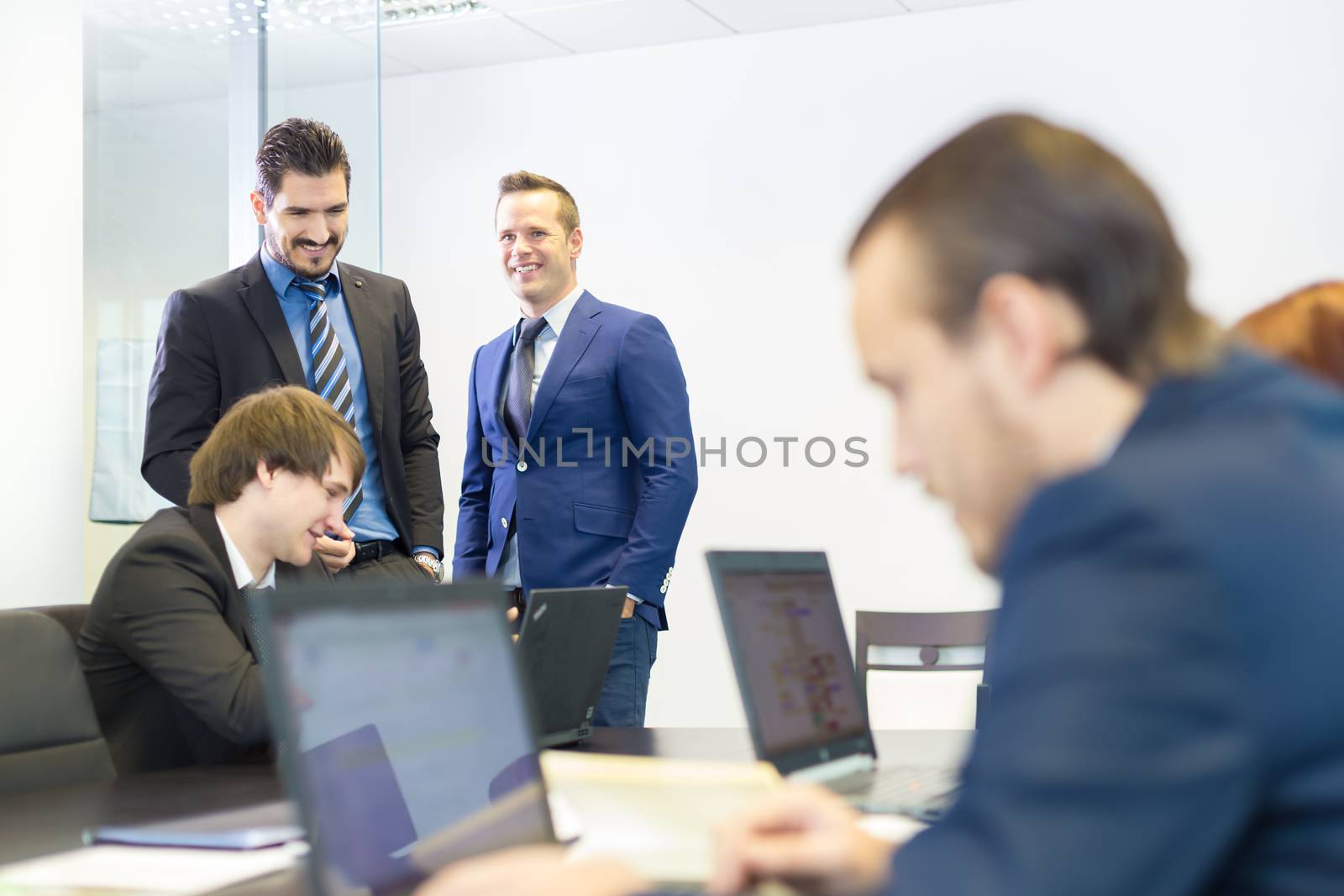 Workplace in modern office with business people brainstorming. Businessman working on laptop during the meeting.