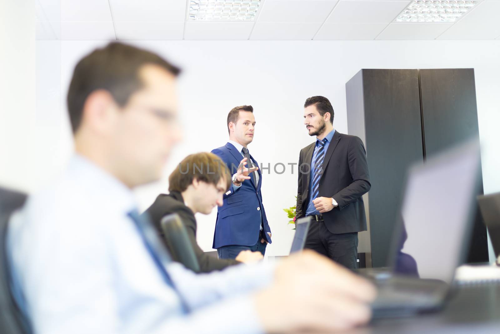 Workplace in modern office with business people brainstorming. Businessman working on laptop during the meeting.