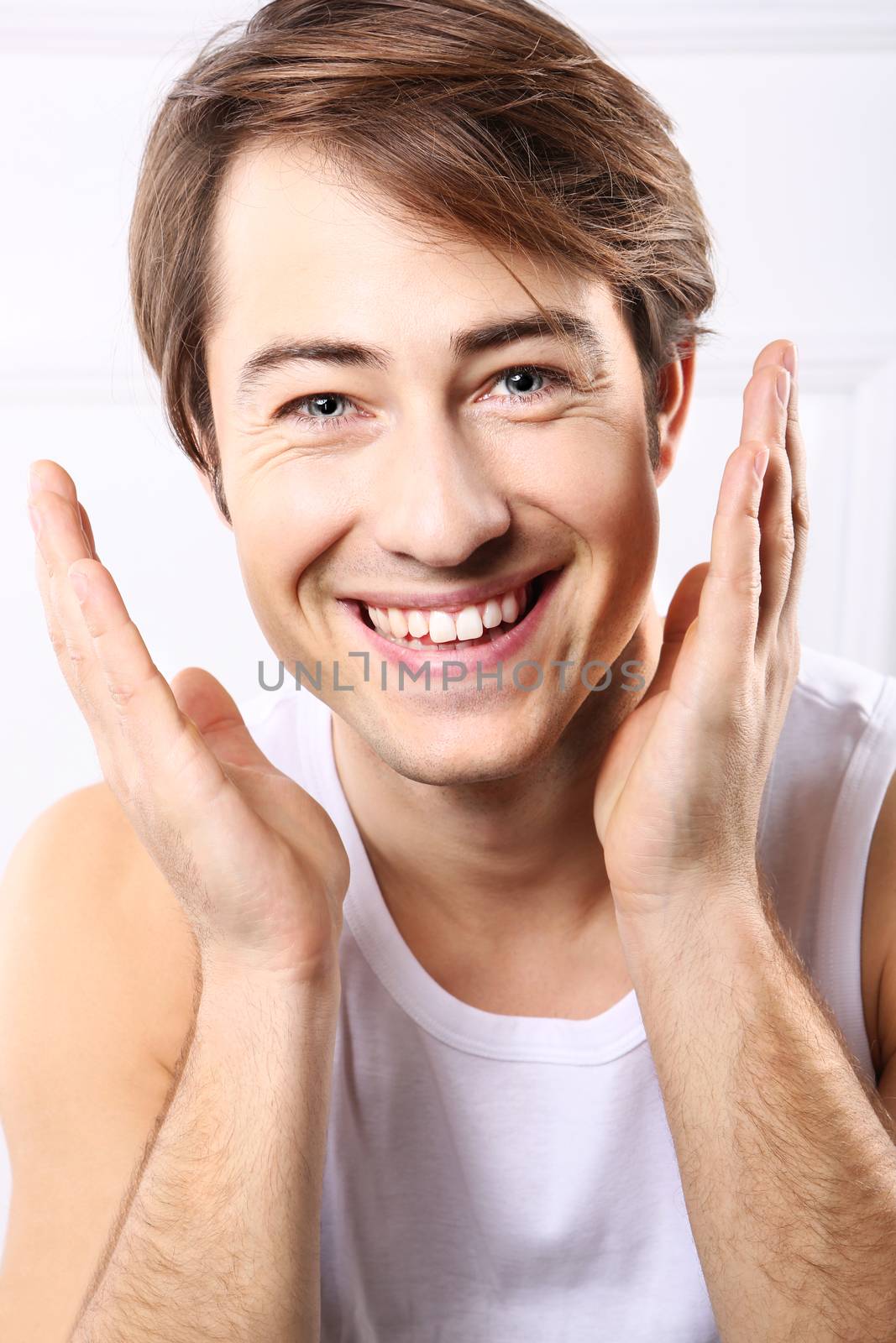 Young handsome man after shave balm is applied on the skin face