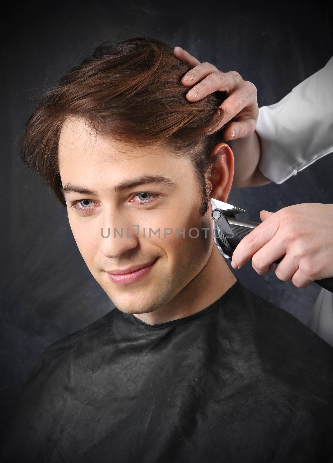 Portrait of a young white boy while cutting hair in the hair salon by robert_przybysz