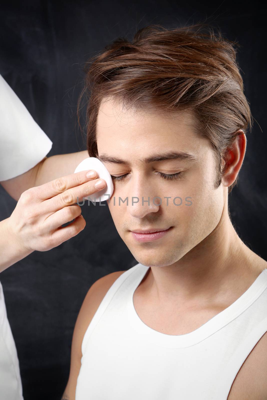Young handsome man during the treatment of facial skin treatment