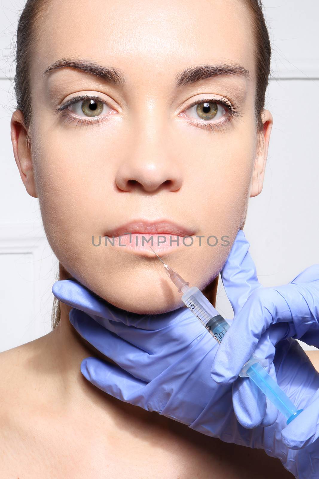 The face of a beautiful woman during the procedure of modeling the mouth, injecting by robert_przybysz