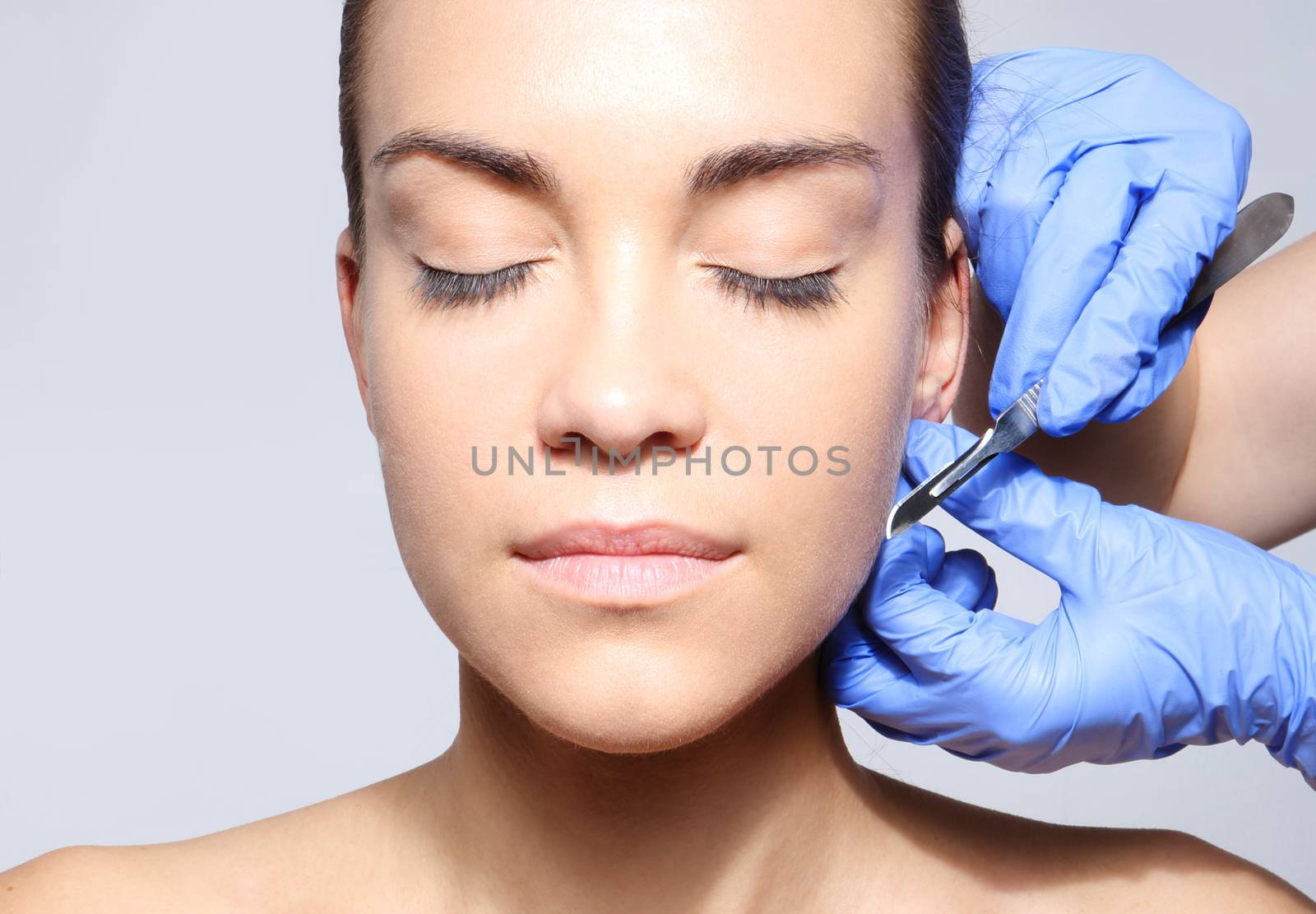 Caucasian woman during surgery using a scalpel