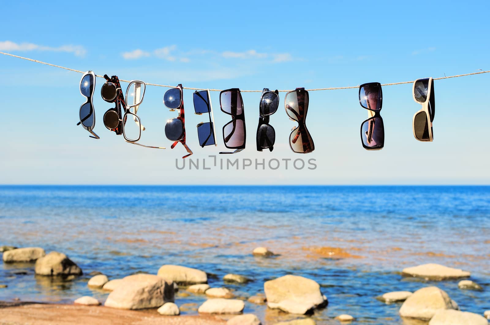 Sunglasses hanging on a rope on a seashore