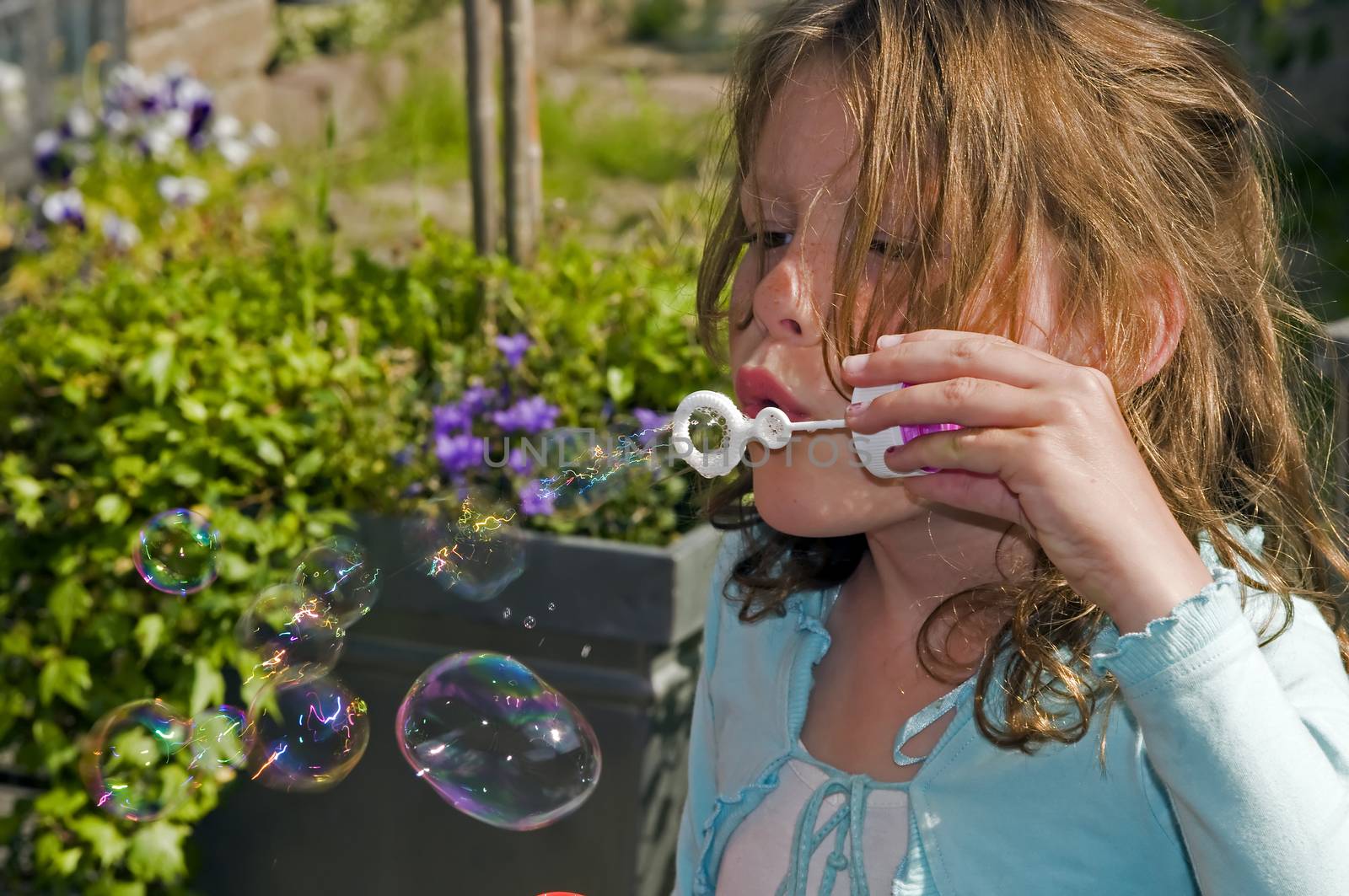 blond causcasian girl blowing bubbles by compuinfoto