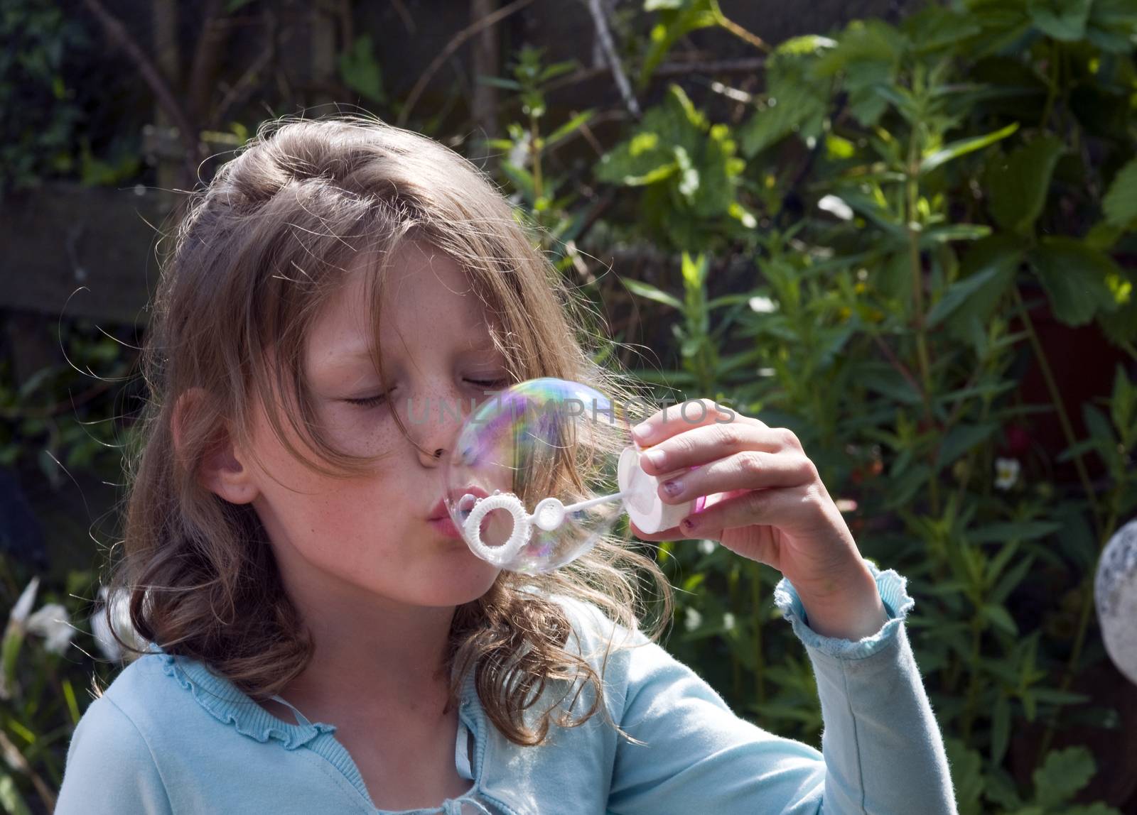 blond causcasian girl blowing  bubbles by compuinfoto