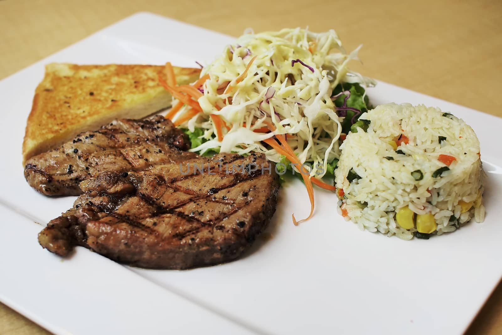 grilled pork steak with garlic bread  and vegetables