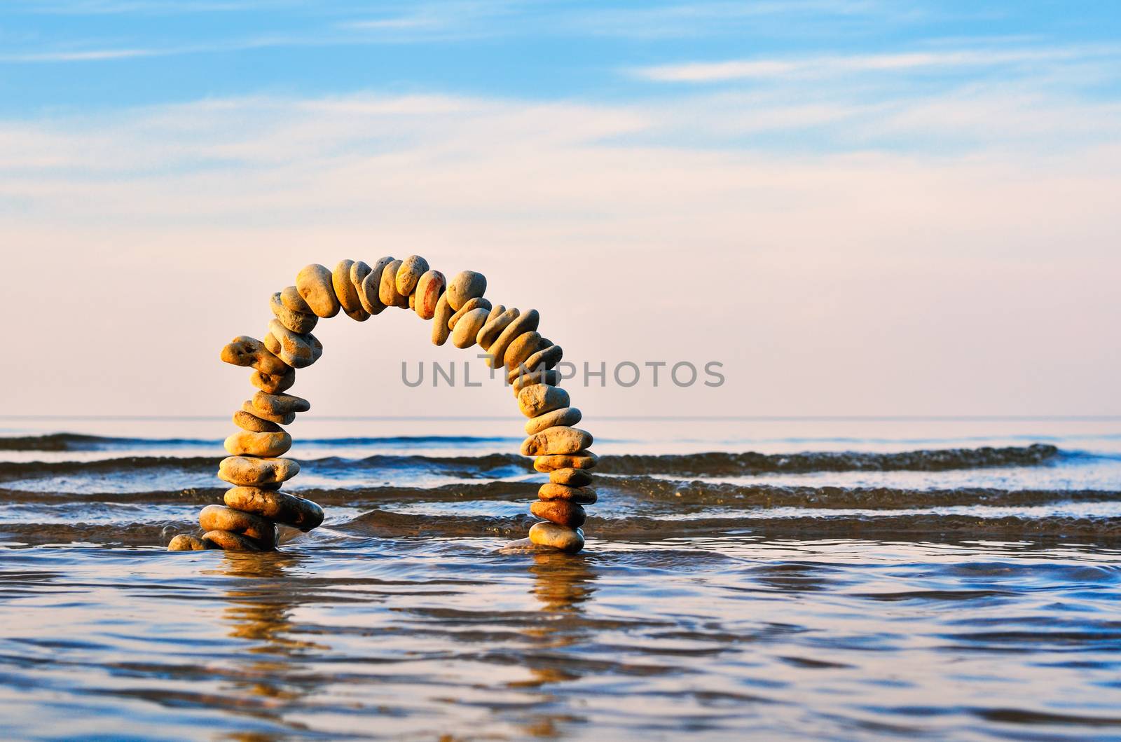 Arch of pebbles on the surface of the sea