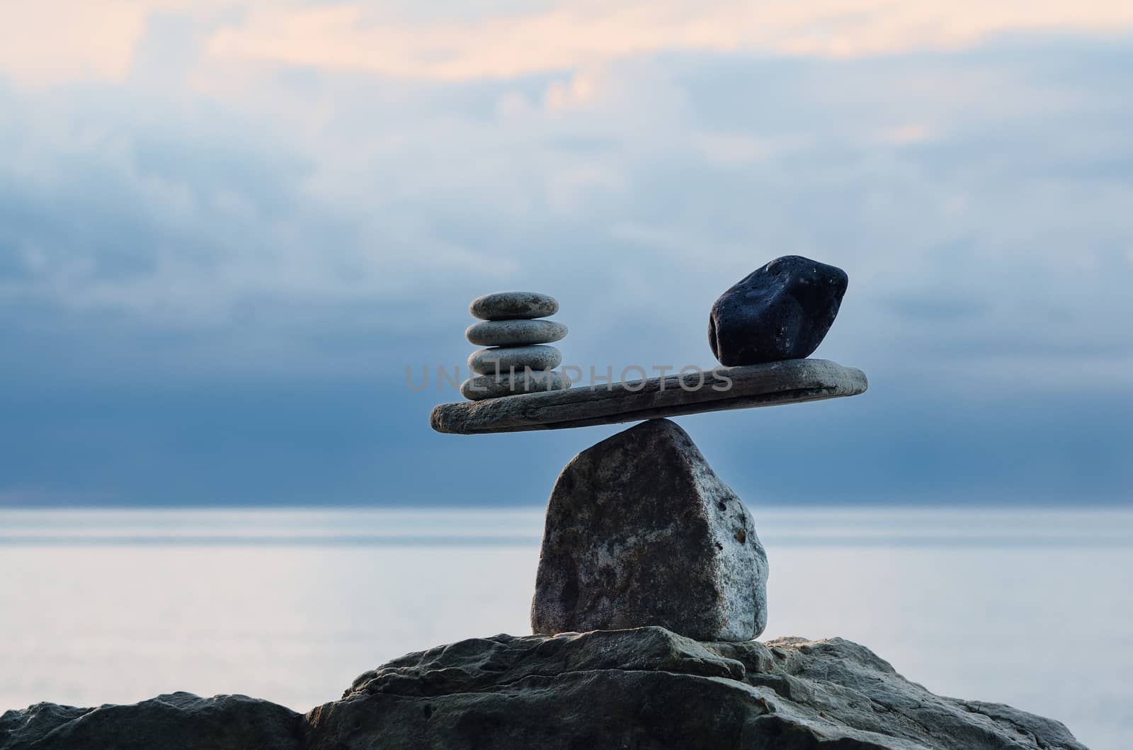 Symbol of scales is made of pebbles on the sea boulder