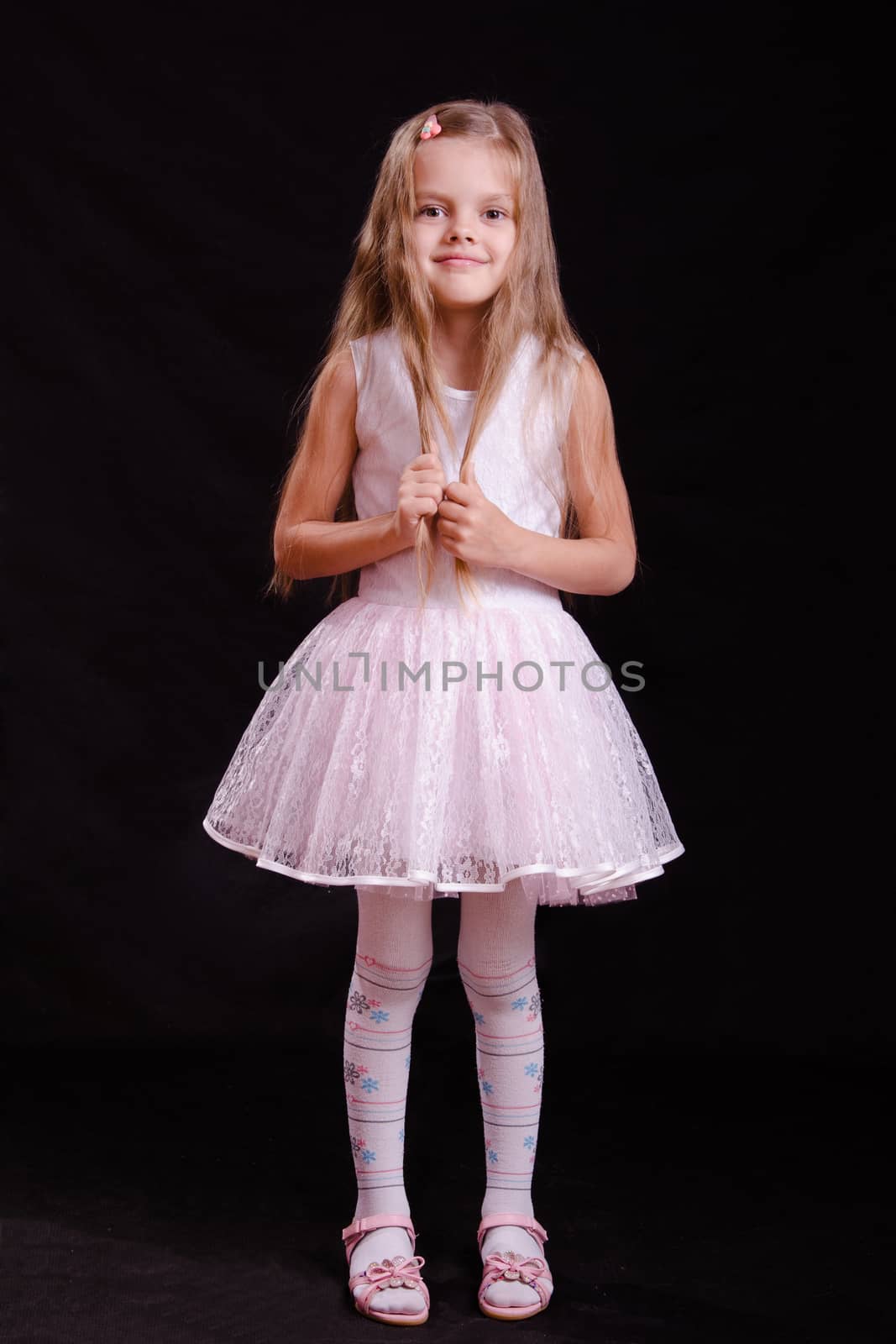 Portrait of a beautiful five year old girl on a black background