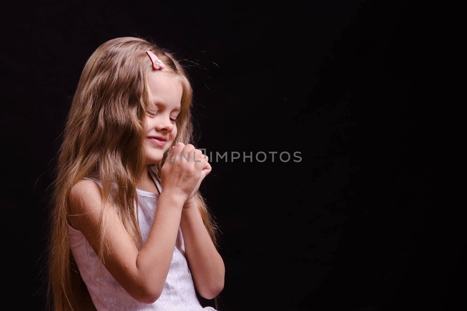 Portrait of a beautiful five year old girl on a black background