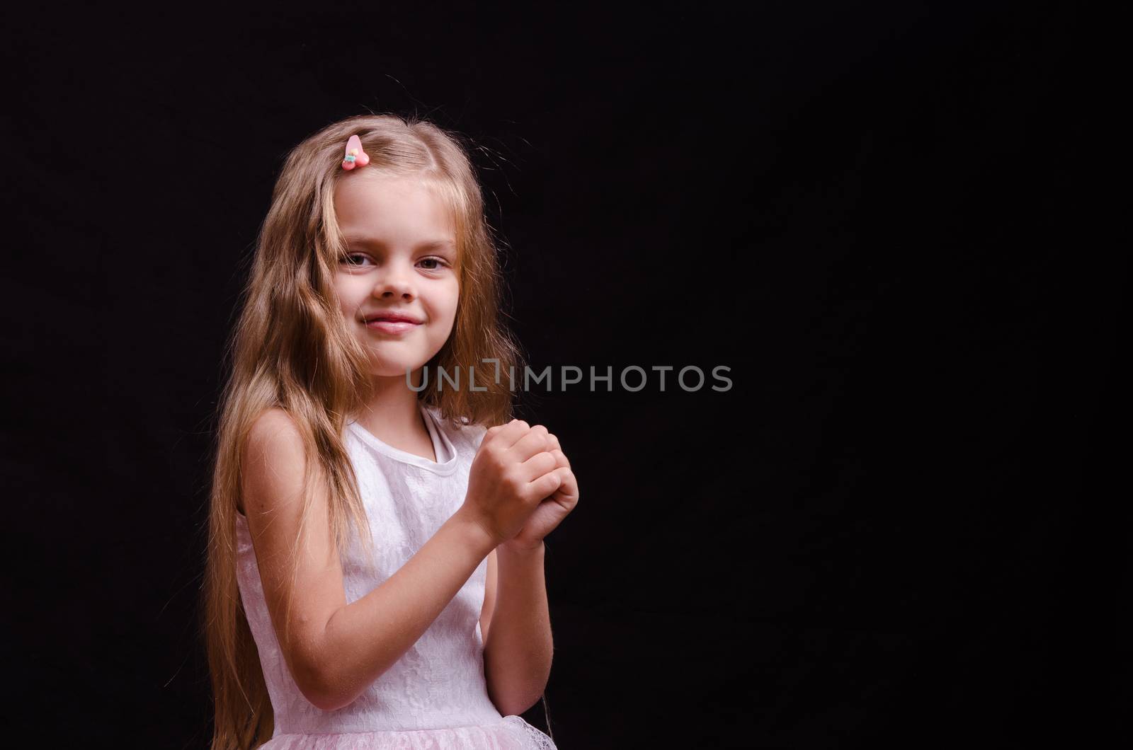 Portrait of a beautiful five year old girl on a black background