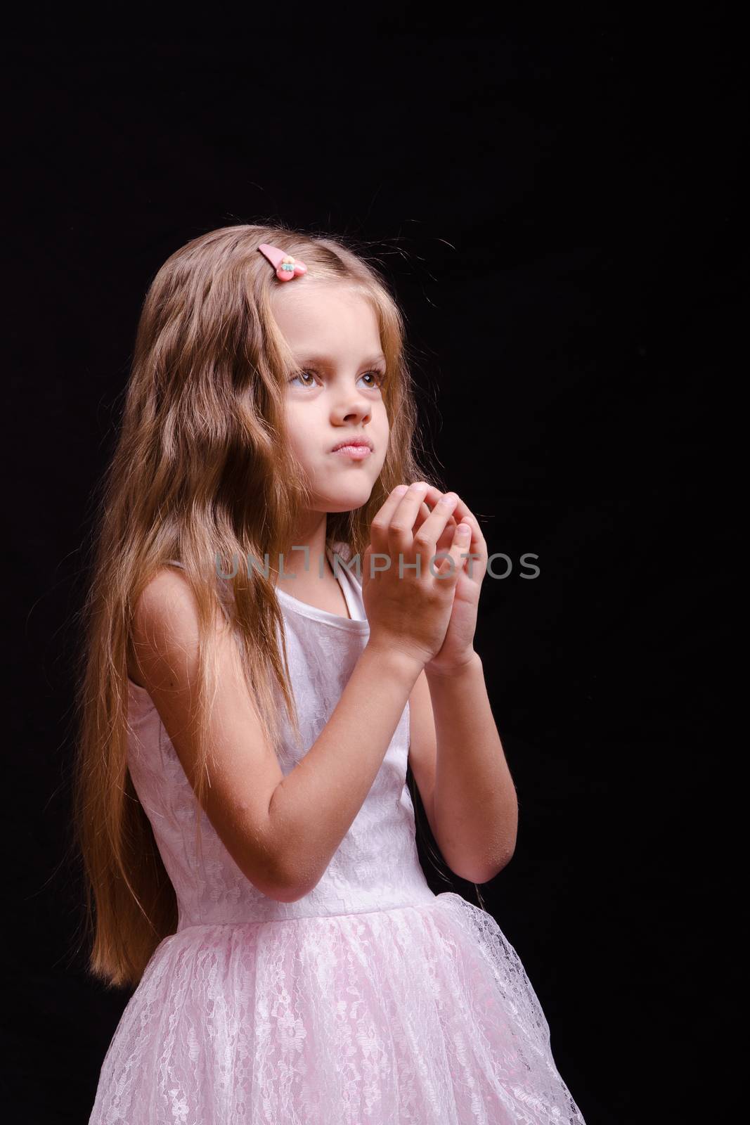 Portrait of a beautiful five year old girl on a black background