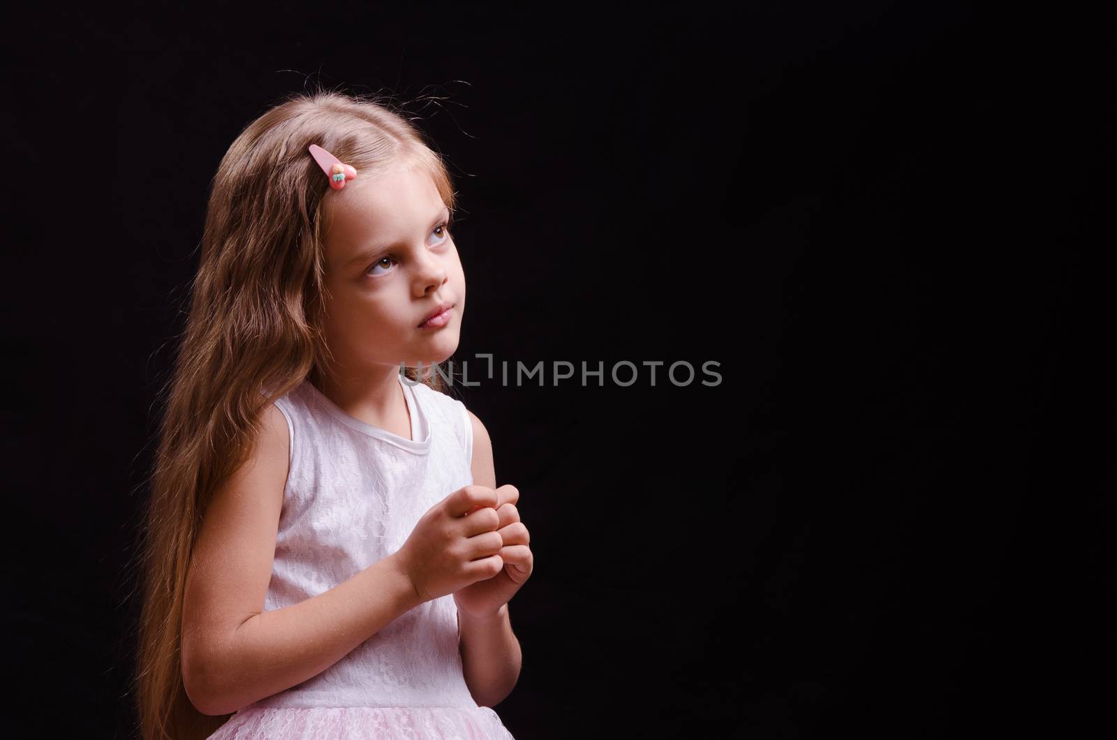 Portrait of a beautiful five year old girl on a black background