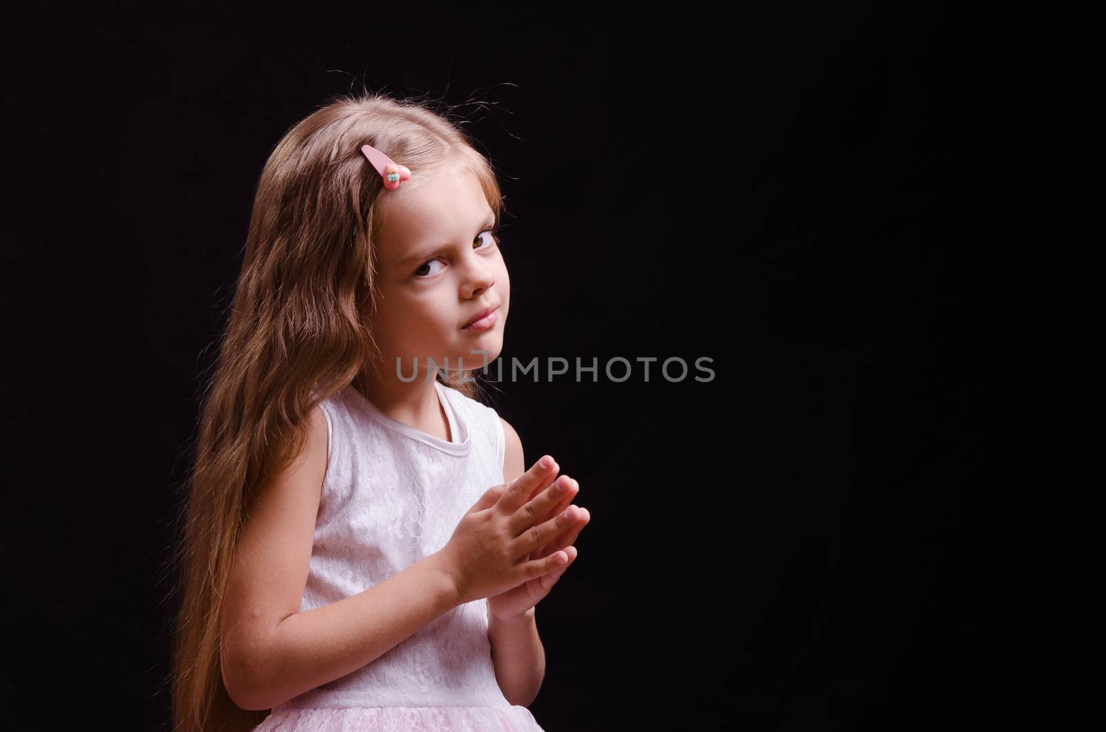 Portrait of a beautiful five year old girl on a black background