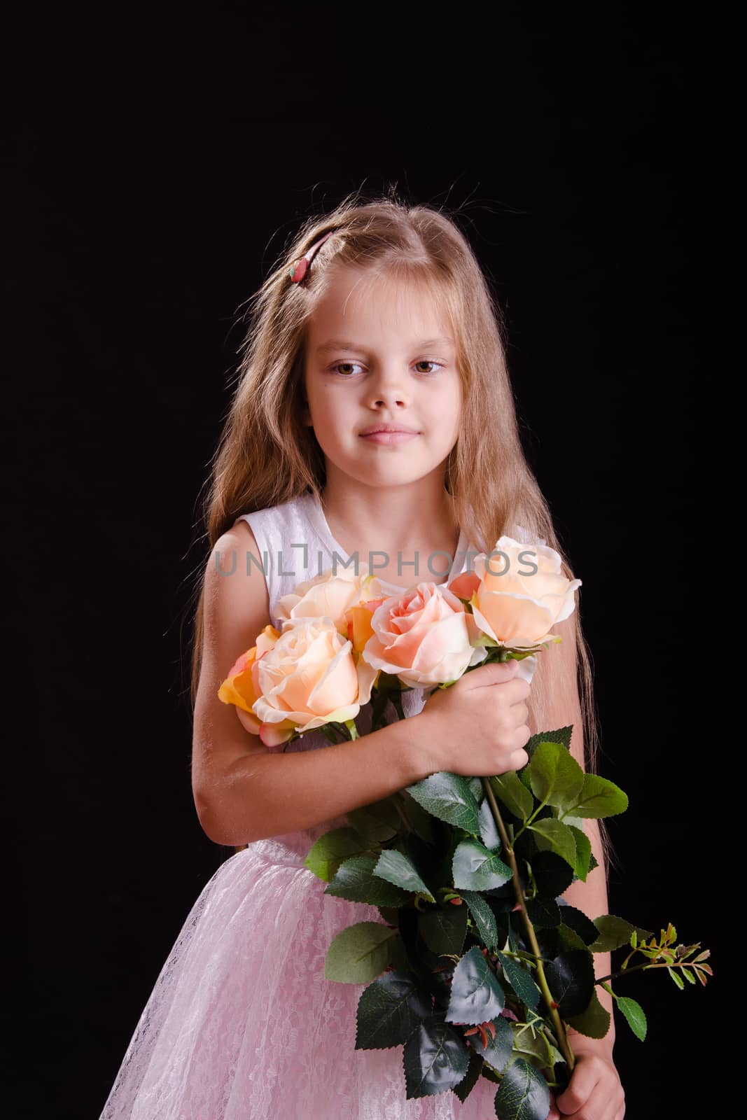Portrait of a five year old girl with a bouquet of flowers on a black background