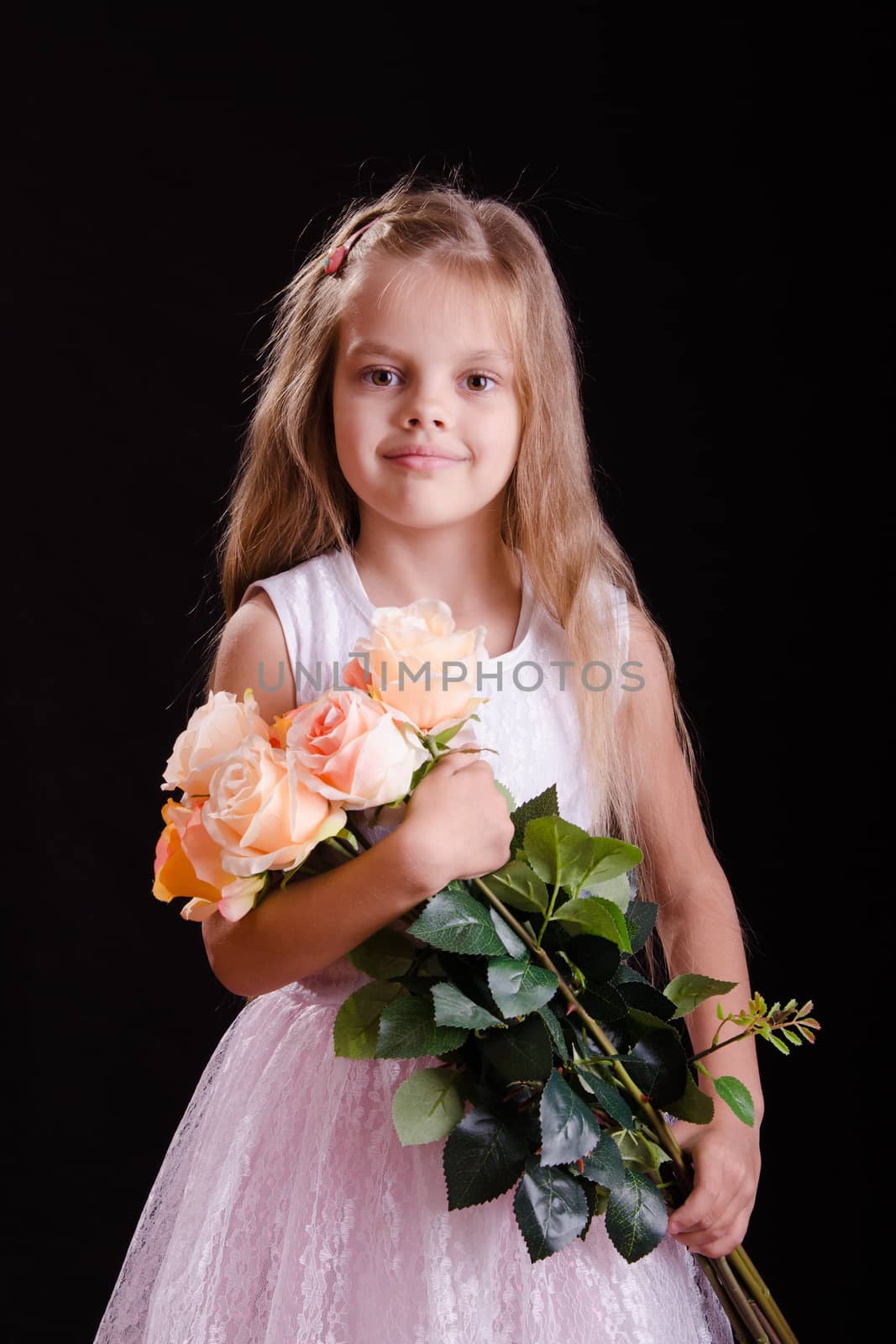 Portrait of a five year old girl with a bouquet of flowers on a black background
