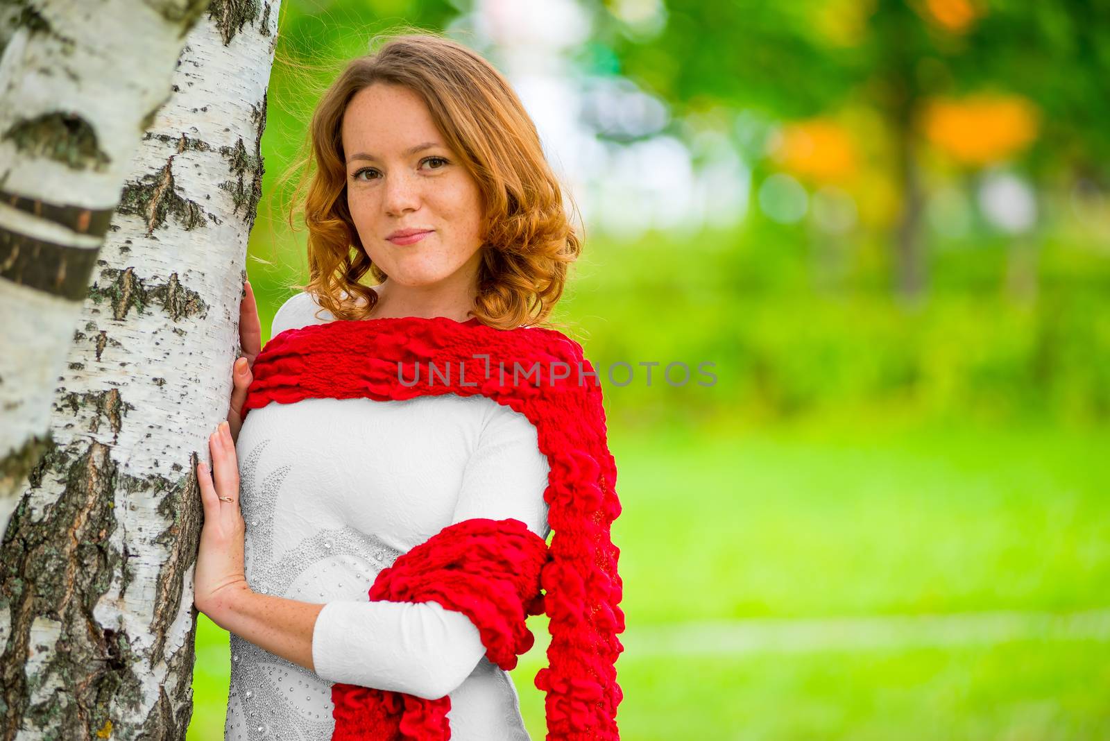 beautiful woman wrapped in a red scarf in the park